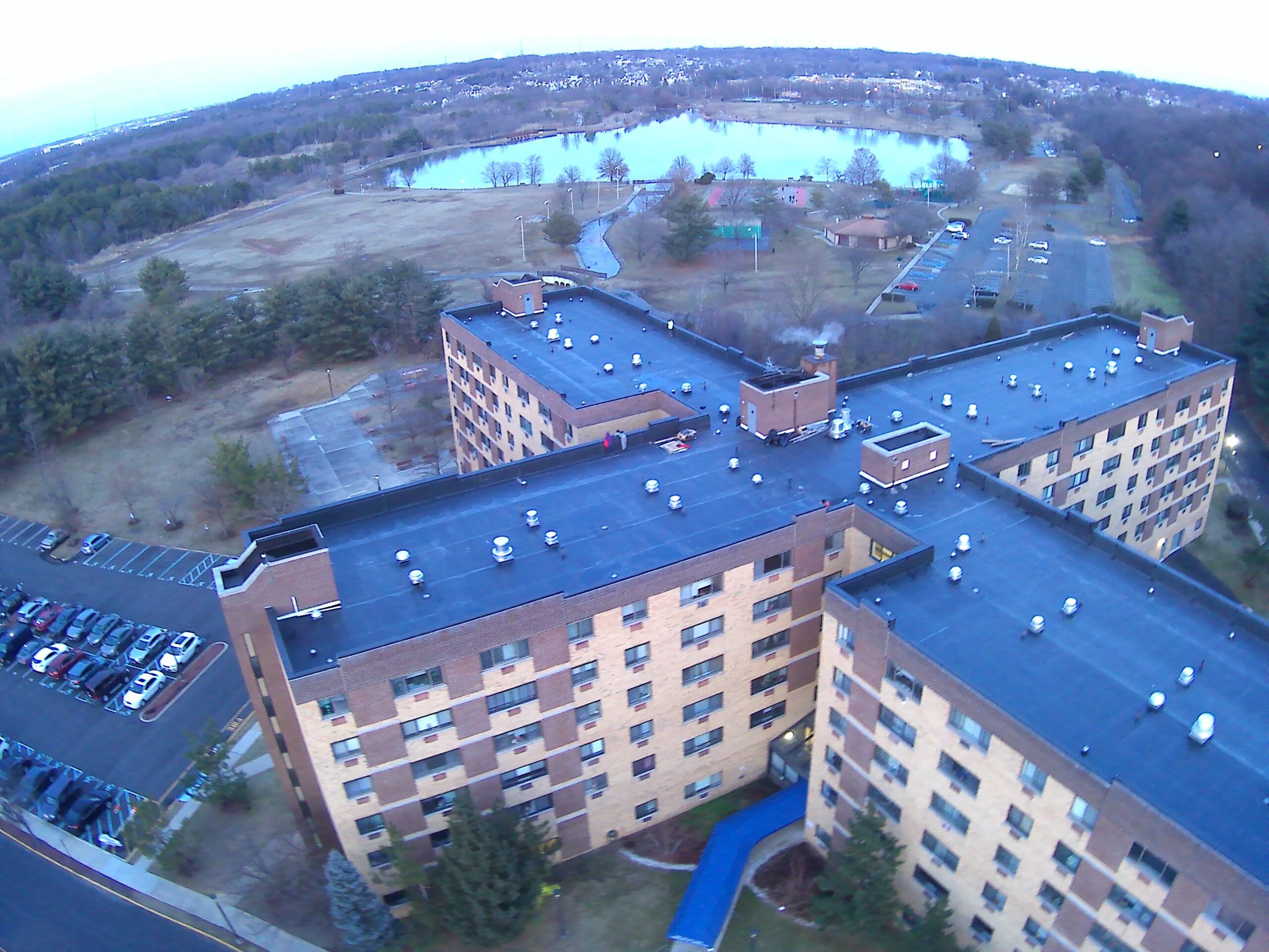 Aerial view of a multi-story brick apartment complex with new roofing across several buildings