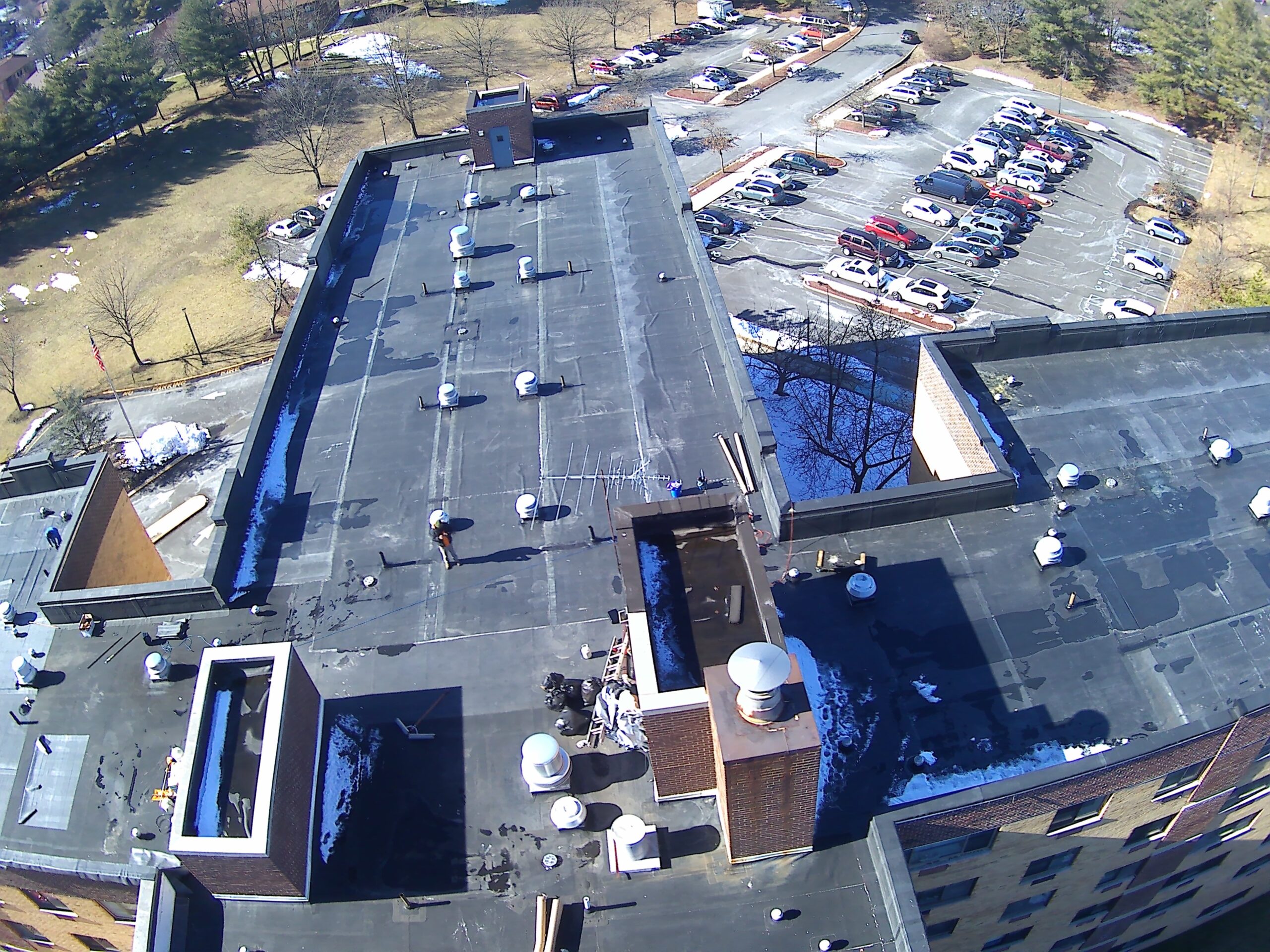 Aerial view of a large commercial building with a newly installed flat membrane roof