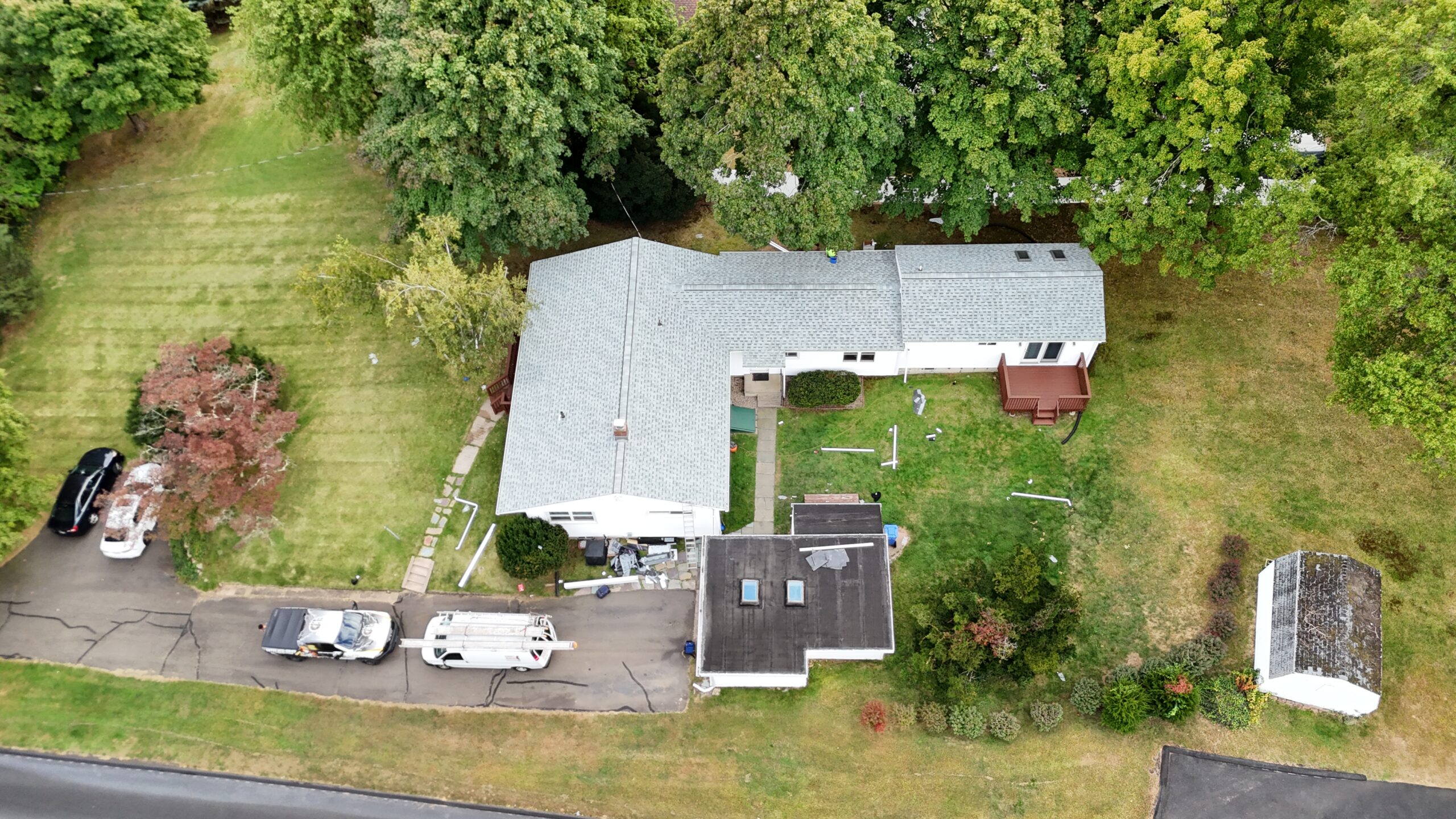 Aerial view of a home with a dark finished roof and a bright green lawn