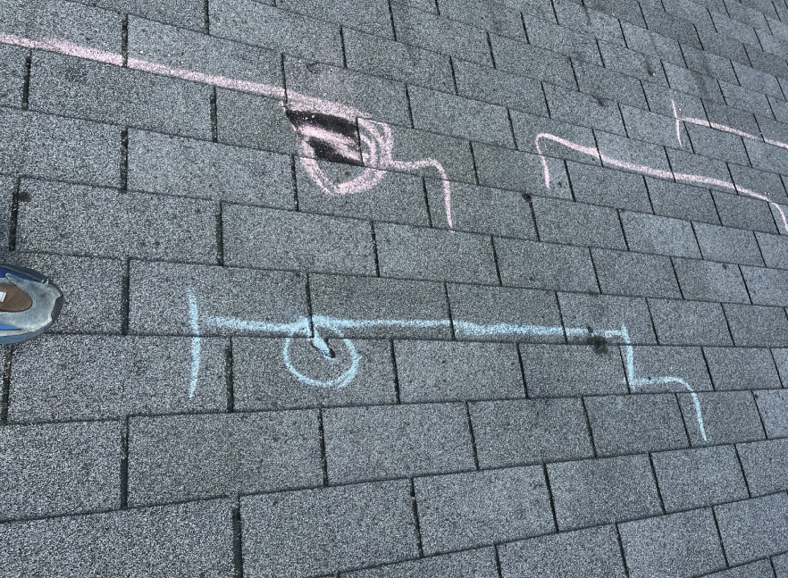 Close-up of chalk layout lines snapped across a shingle roof deck during installation