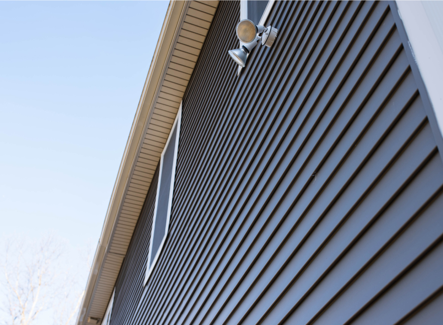 Corner of a home clad in dark vertical siding installed by Everett Construction